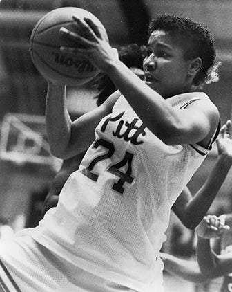 a black and white photo of Johnson with a basketball in her hands