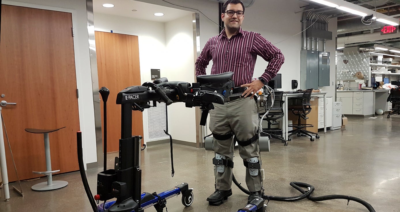 Sharma with his hands on his hips wearing the exoskeleton leg braces