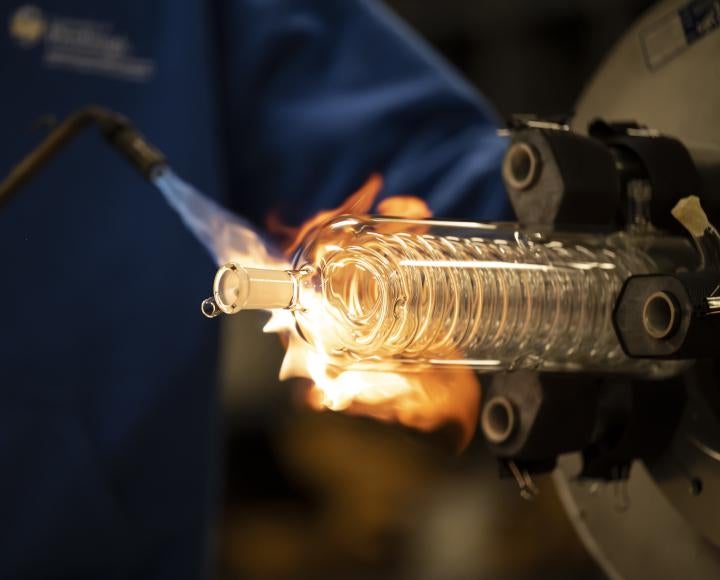 Ryan Tate heats up a glass apparatus with a blowtorch