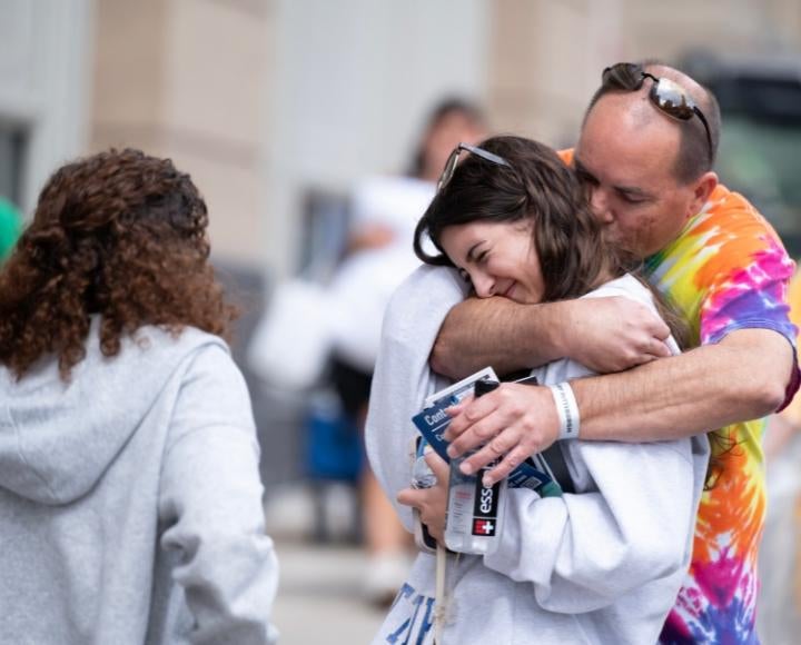 A parent embraces a student.