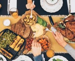 People grabbing food from table during a feast