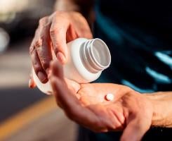 pouring a pill out of a bottle