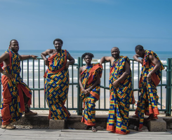 five men in colorful dress on a beach