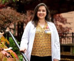 a person in a yellow blouse and white coat