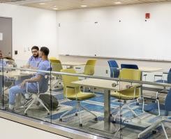 Students in scrubs sit in a lofted study area in Salk Hall