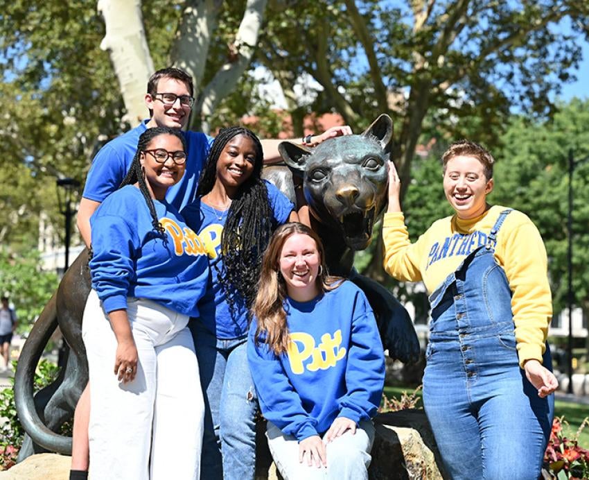 Students in Pitt gear stand around a panther statue