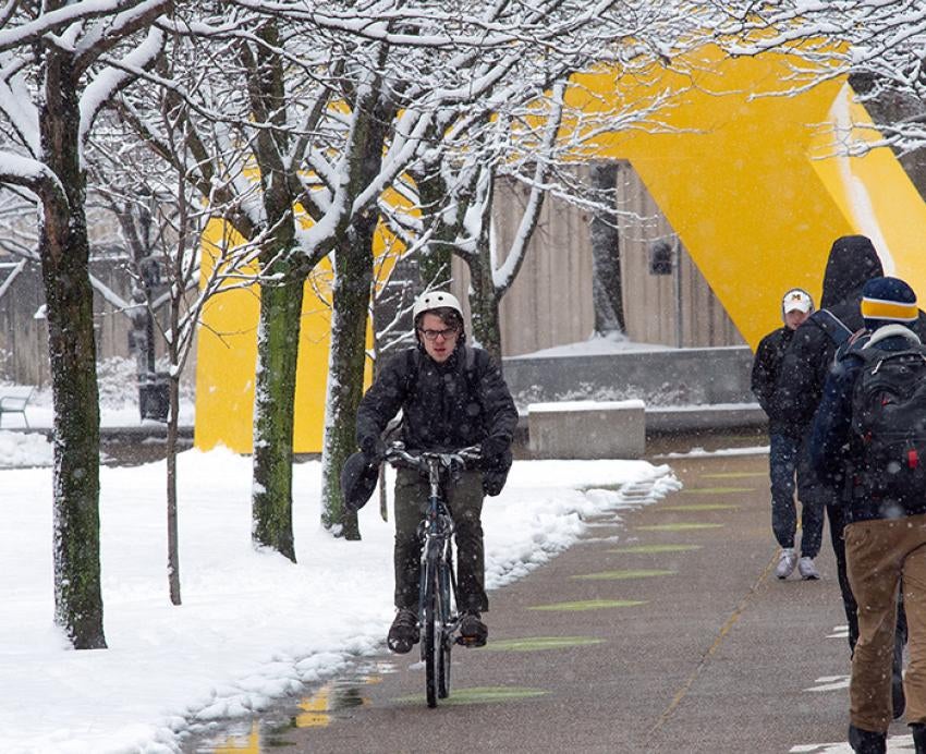 A person bikes on a snowy day