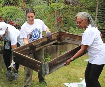 Volunteers lift a garden bed
