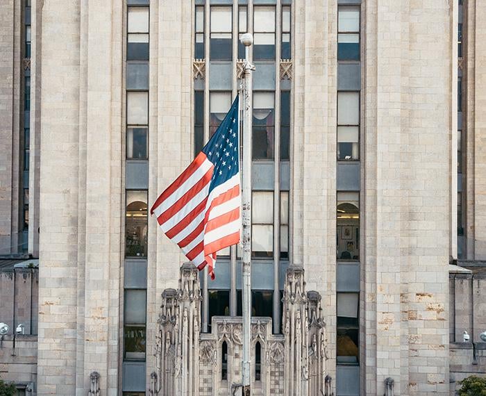 An American flag on a pole outside the Cathedral of Learning